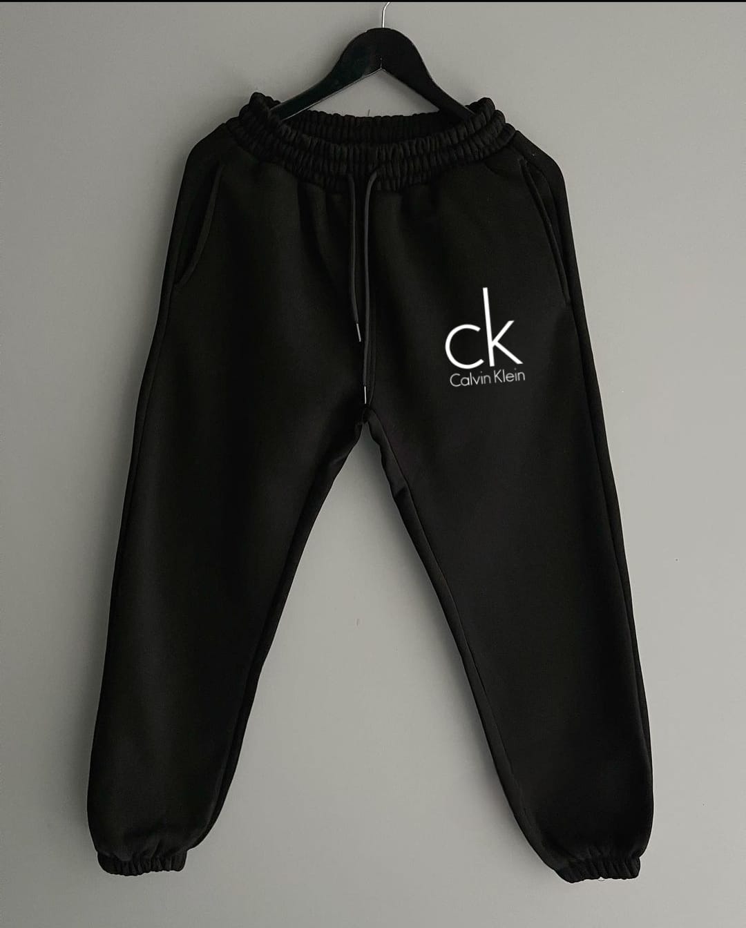 CK trousers featuring a sleek and modern design with the iconic Calvin Klein branding. The trousers offer a clean, minimalist aesthetic with a tailored fit, perfect for both casual and semi-formal occasions. Made from high-quality, comfortable fabric, these trousers are ideal for those seeking timeless style and sophisticated simplicity in their wardrobe