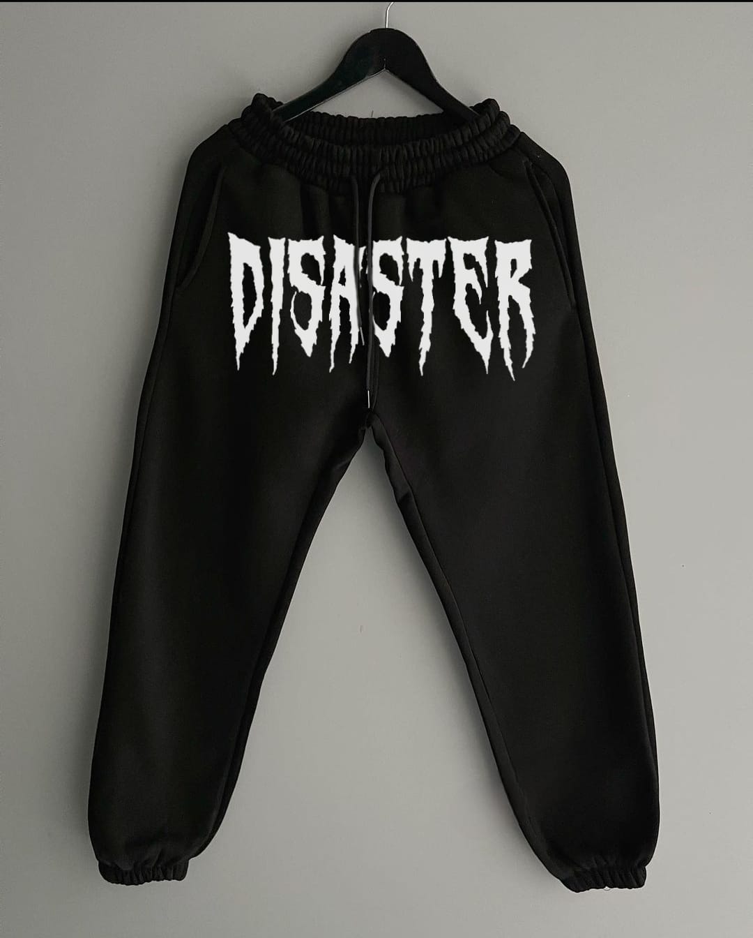 Disaster trousers featuring an edgy, bold design that captures a sense of rebellion and uniqueness. The pants may include distressed details, graphics, or unconventional patterns that symbolize chaos or an artistic twist on streetwear. Made from durable fabric, these trousers are both stylish and comfortable, perfect for those who want to stand out with their fashion choices