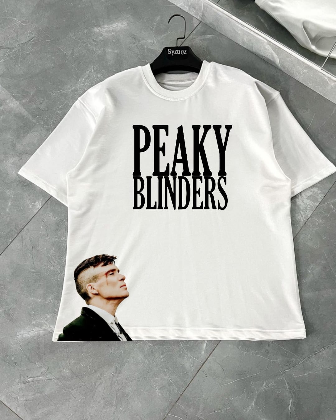 Graphic T-shirt inspired by the iconic 'Peaky Blinders' series, featuring bold and vintage-inspired typography or imagery related to the show's gritty, 1920s Birmingham setting. The design often includes symbols like flat caps, sharp suits, and the Peaky Blinders logo, capturing the essence of the show’s rebellious and stylish characters. Made from soft, high-quality fabric, this T-shirt combines comfort with a nod to the timeless appeal of the gangsters' fashion and attitude, perfect for fans of the series