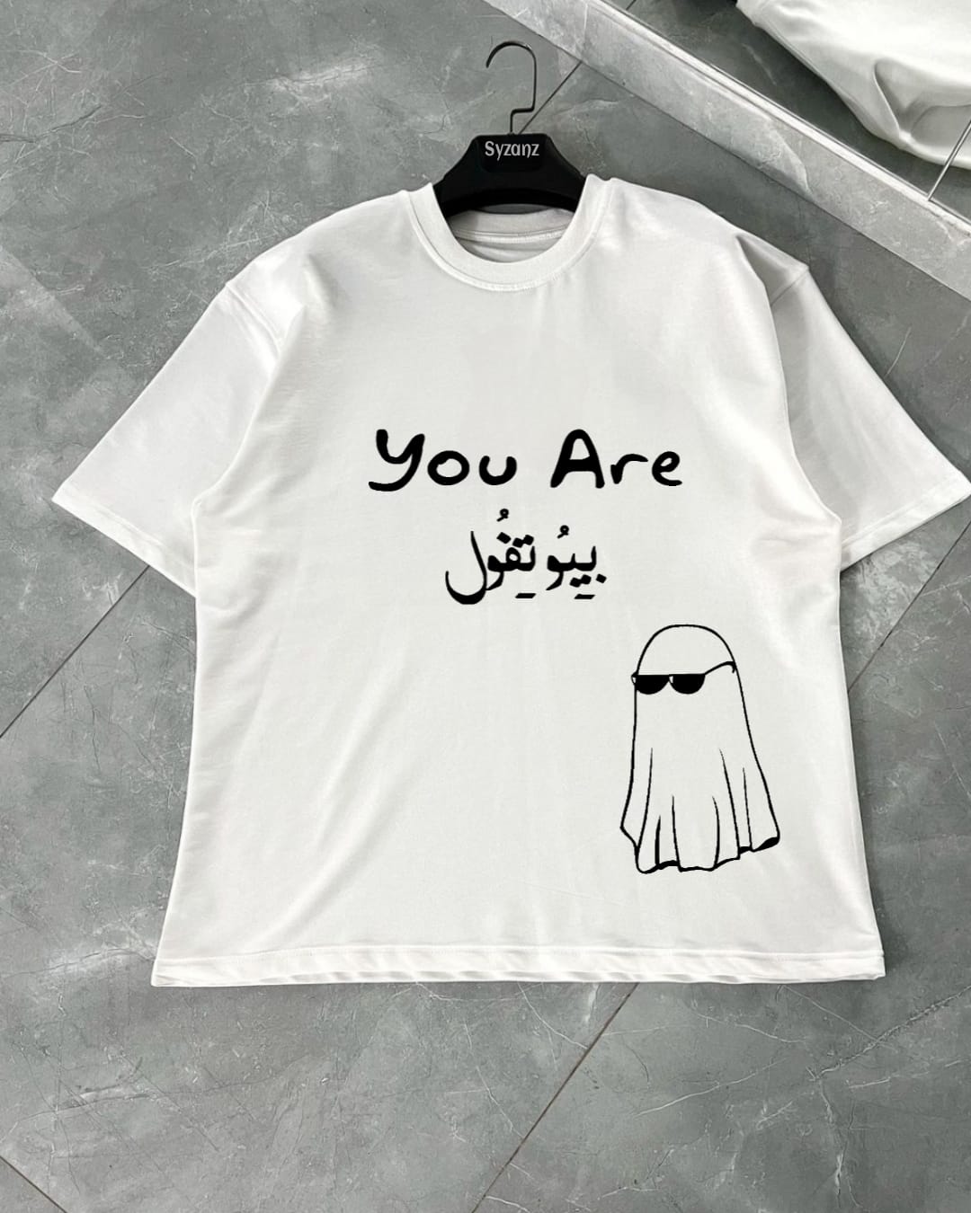 Graphic T-shirt featuring the 'Phantom Grace' design, which depicts a ghostly figure surrounded by an aura of mystery and elegance. The print incorporates soft, ethereal imagery with a subtle, haunting ghost figure, while the phrase 'You Are Beautiful' is prominently displayed, adding a contrast of warmth and positivity. The design blends supernatural elements with uplifting messaging, creating a unique and intriguing aesthetic. Made from soft, premium fabric, this T-shirt combines comfort creatively .